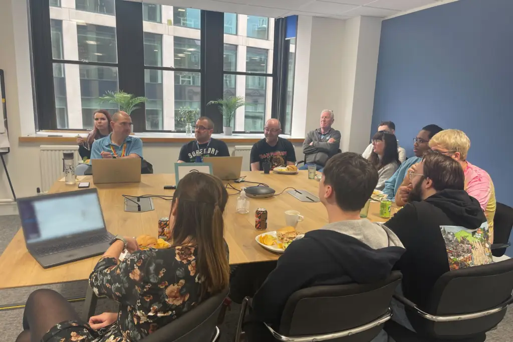 Large group of professional service engineers having a meeting around a large square table.